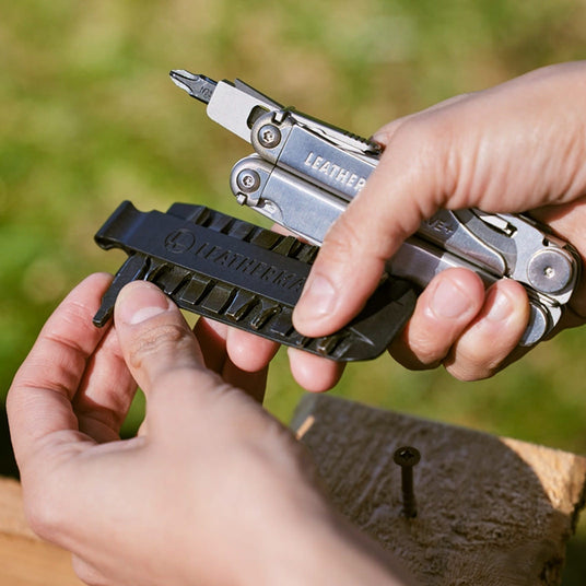 Translation missing: en.Hand holding Leatherman Wave Plus with a bit installed while another bit is being removed from a Bit Kit