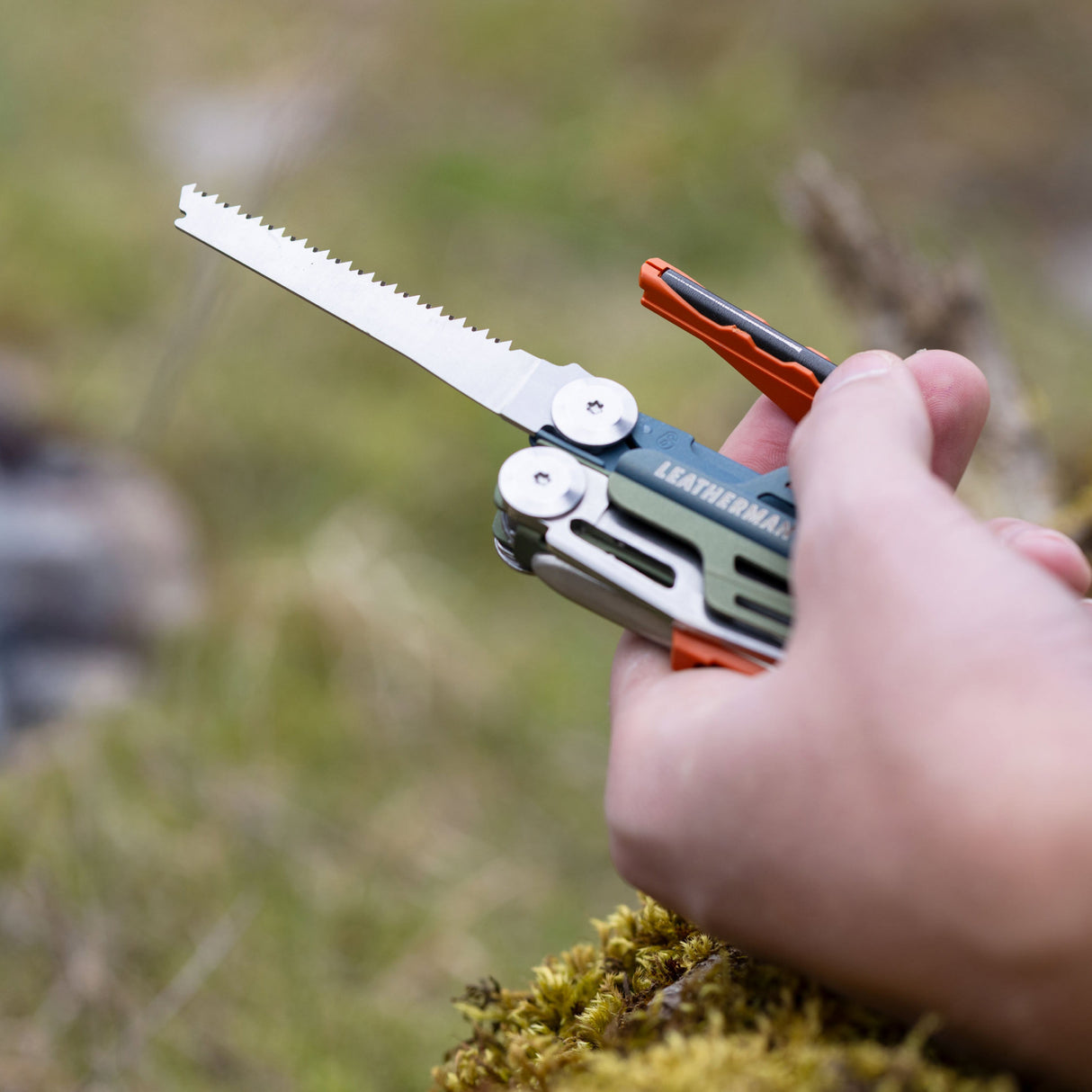 Translation missing: en.A close-up of a person’s hand clutching a Tundrascape Leatherman Signal®, ready to use the fire starter and saw