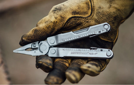Translation missing: en.Close-up of a gloved hand holding a Leatherman Rebar multi-tool with pliers extended, showcasing durable tools designed for work and jobsite tasks