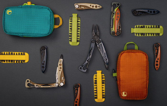 Translation missing: en.Assorted Leatherman tools, bit kits, and tool pouches arranged on a dark background for versatile outdoor use