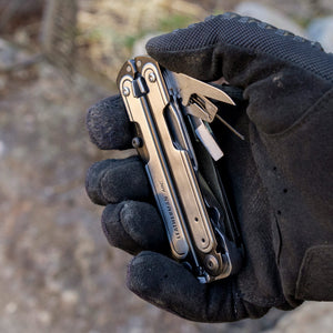 Translation missing: en.Black DLC &amp; Stainless Steel Leatherman ARC® held in a gloved hand, showcasing some tool included tools