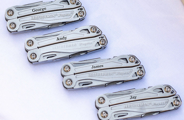Translation missing: en.Four personalized Leatherman Wingman multi-tools engraved with names, displayed diagonally on a white background as customizable go-to gift options