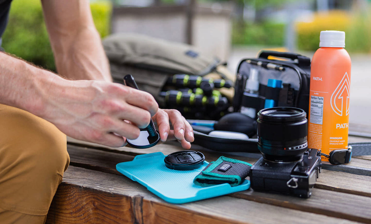 Translation missing: en.Man using Leatherman® Adapt Kit tray to clean camera lens