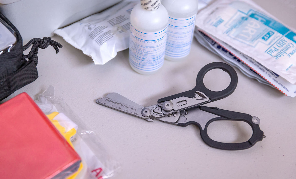Translation missing: en.Black Leatherman Raptor® Rescue open on a desk with first aid supplies