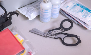 Translation missing: en.Black Leatherman Raptor® Rescue open on a desk with first aid supplies
