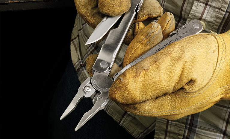 Translation missing: en.Man in green plaid shirt and yellow leather gloves pulling knife blade out of Leatherman Super Tool 300