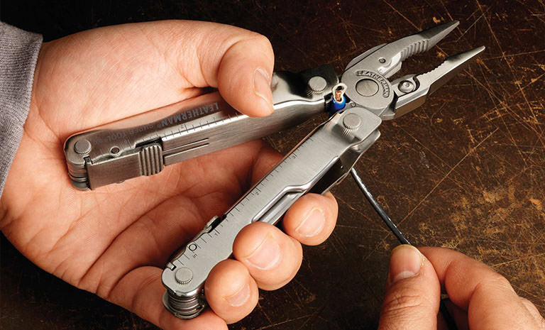 Translation missing: en.Man using Leatherman Super Tool 300 to strip wire