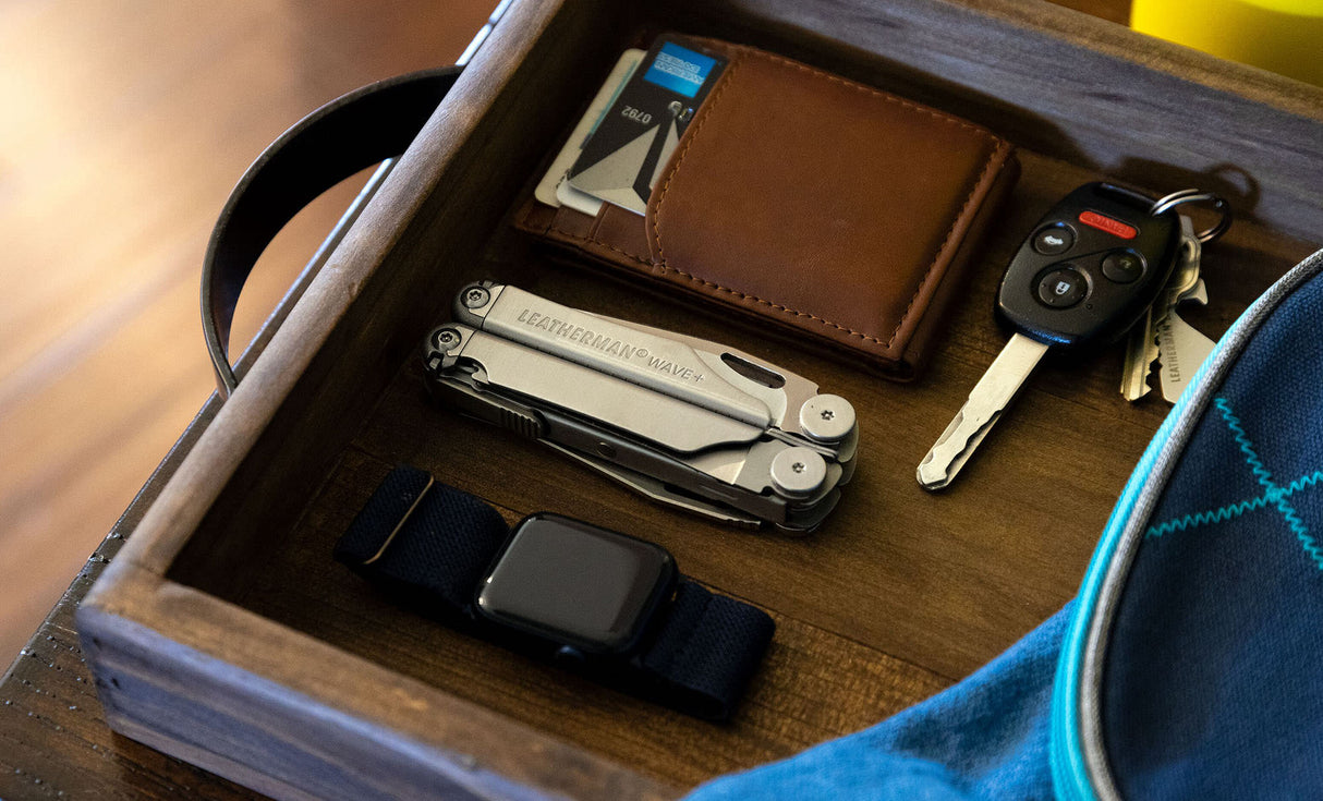 Translation missing: en.Stainless Steel Leatherman Wave® Plus multi-tool in a wooden vanity with wallet, keys, and smartwatch