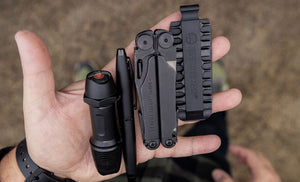Translation missing: en.Hands showcasing a Black Leatherman Wave® Plus, bit kit, pen, and flashlight
